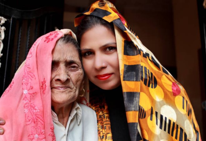 Two women standing together, wearing colourful scarves